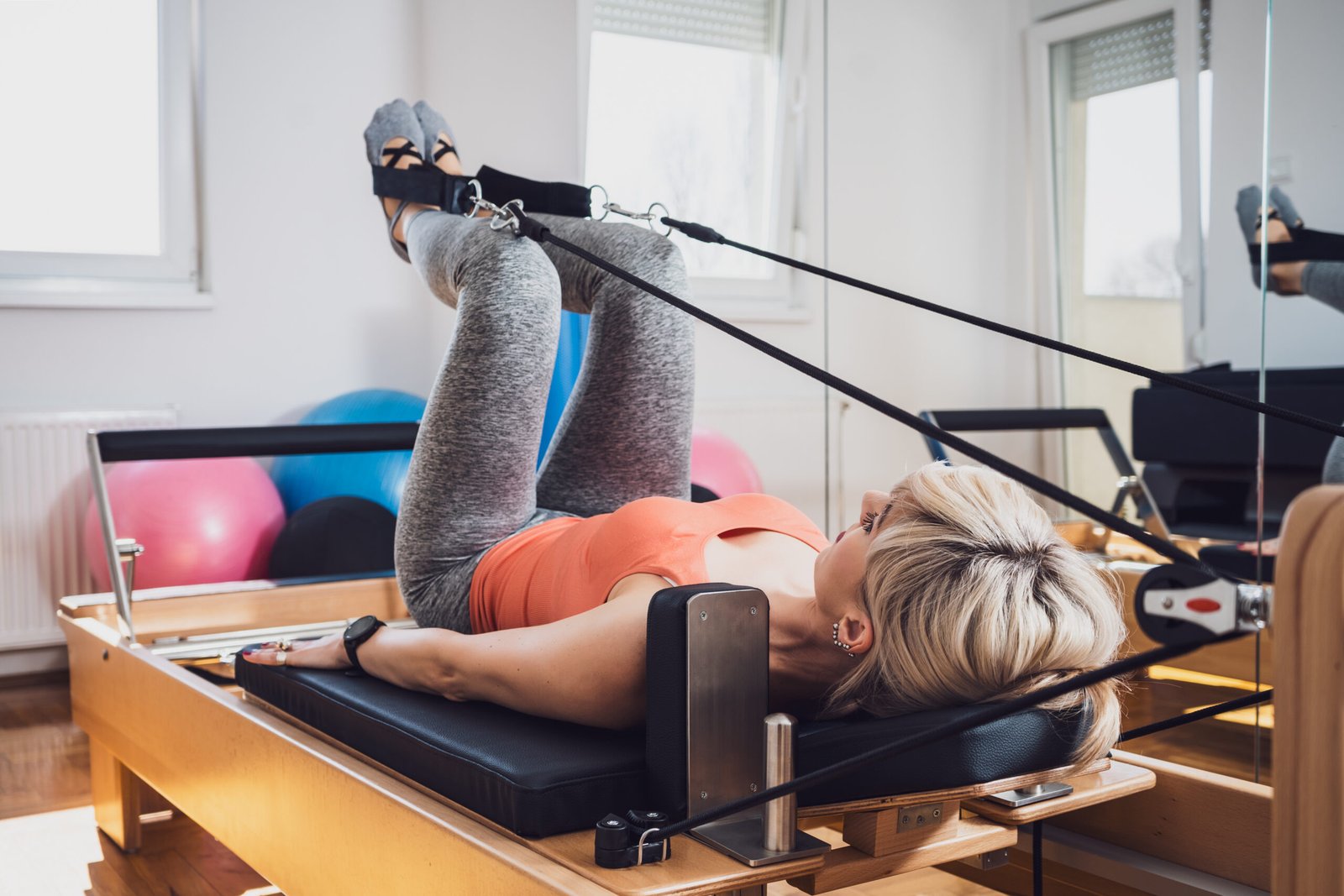vecteezy_blonde-woman-is-exercising-on-pilates-reformer-bed-in-her-home_23253675